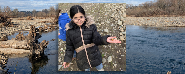 student holding a rock found on an east fork lewis river field trip