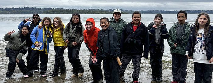 a group of students poses in front of Vancouver Lake