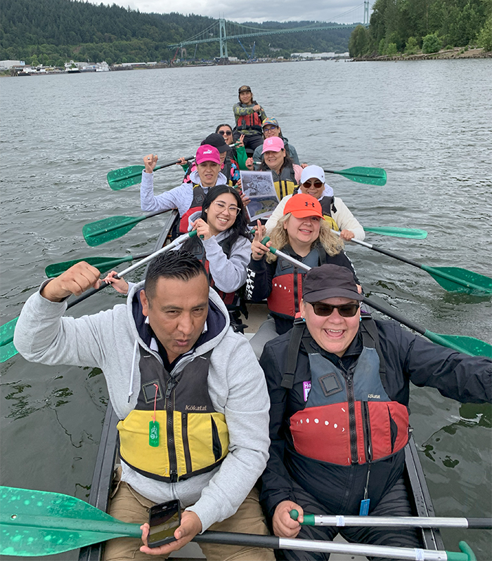 a group of adults in a Big Canoe on the Willamette