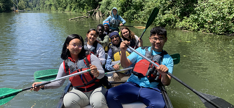 group of youth paddle a Big Canoe